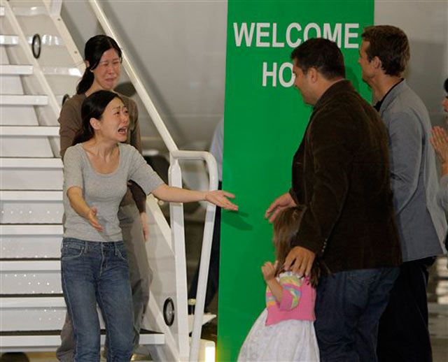 Euna Lee (in grey shirt) and Laura Ling react upon seeing their familyâ(from left) Lee's daughter Hana, Lee's husband Michael Saldate, and Ling's husband Ian Clayton
